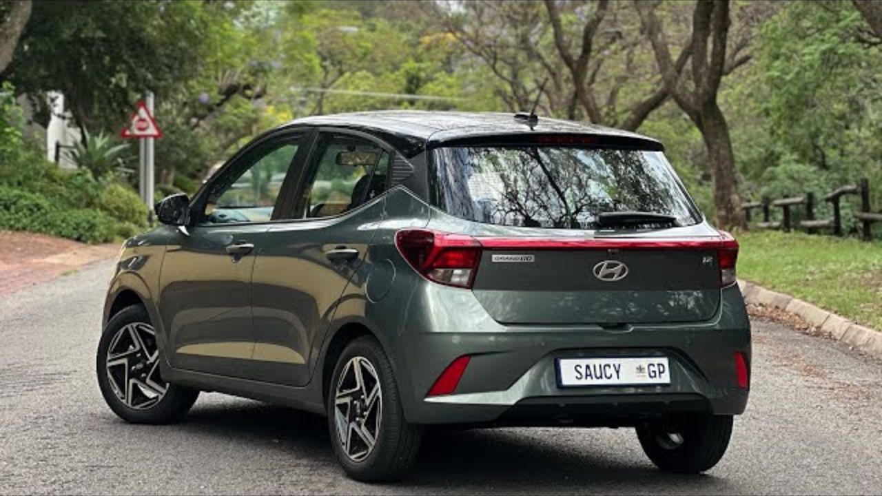 Hyundai Grand i10 in light grey color on road near some trees