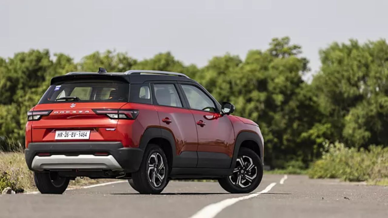 Maruti Brezza in red color on road infront of many trees