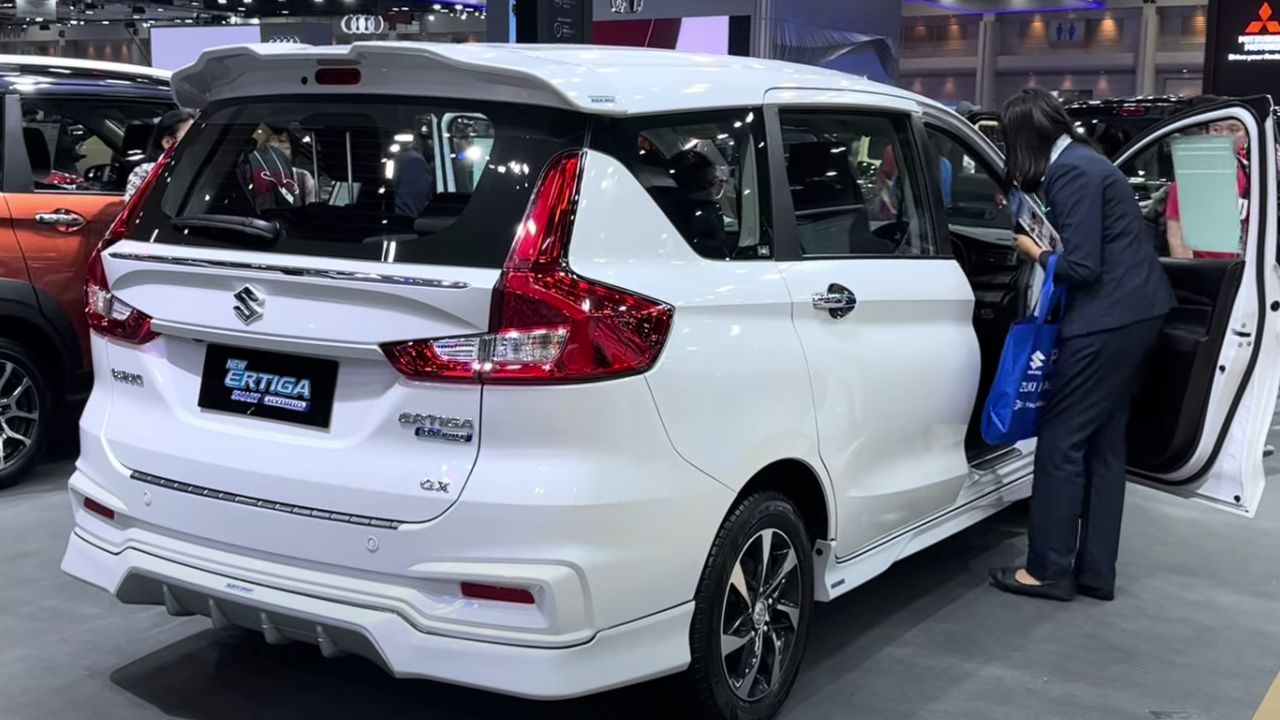 New Maruti Ertiga in white color in showroom with one ladies and many car