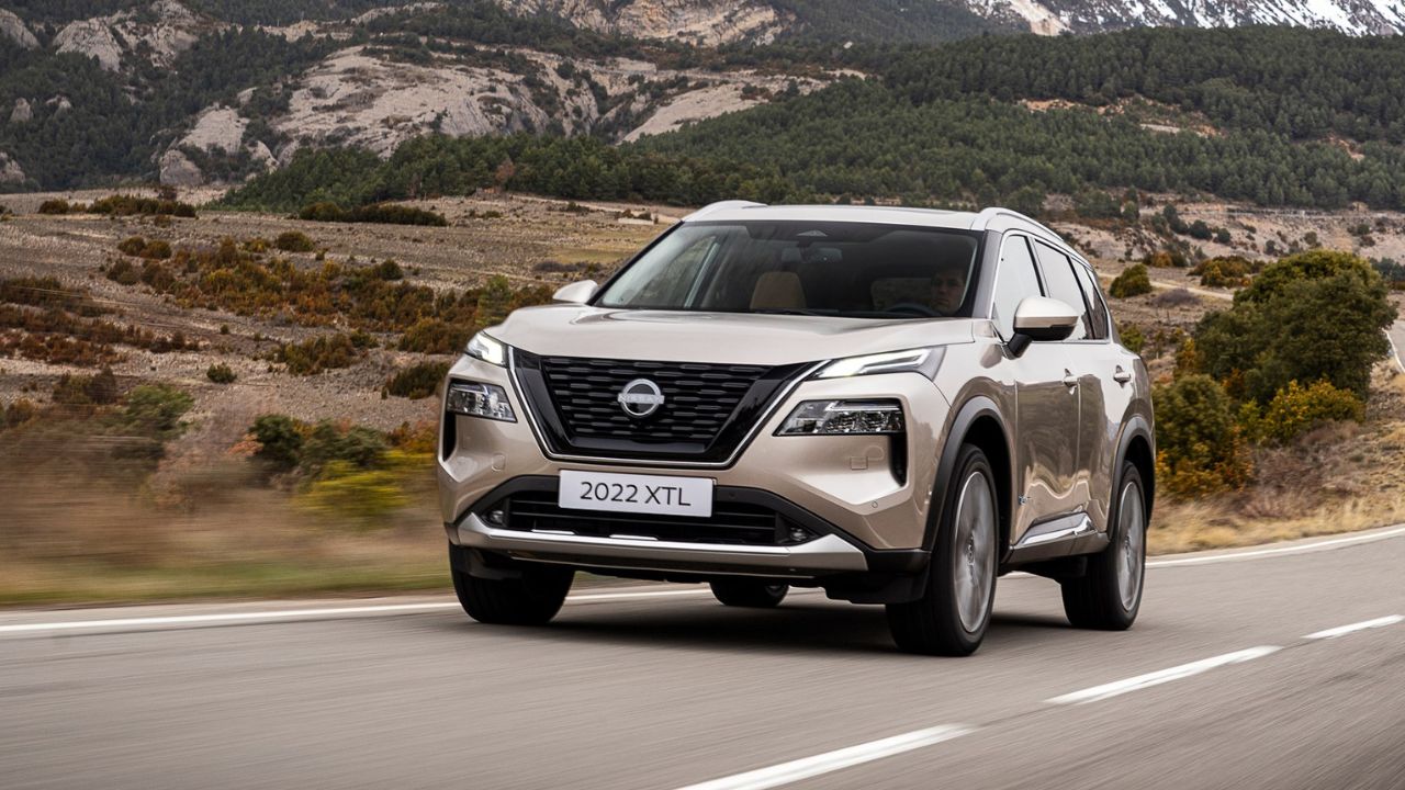 New Nissan X-Trail in light gold color on road near mountains