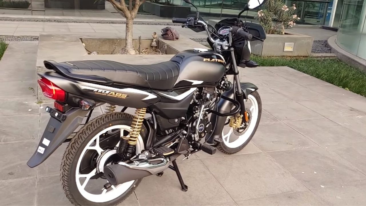 bajaj platina 110 abs in grey and black color on flat surface outside a house