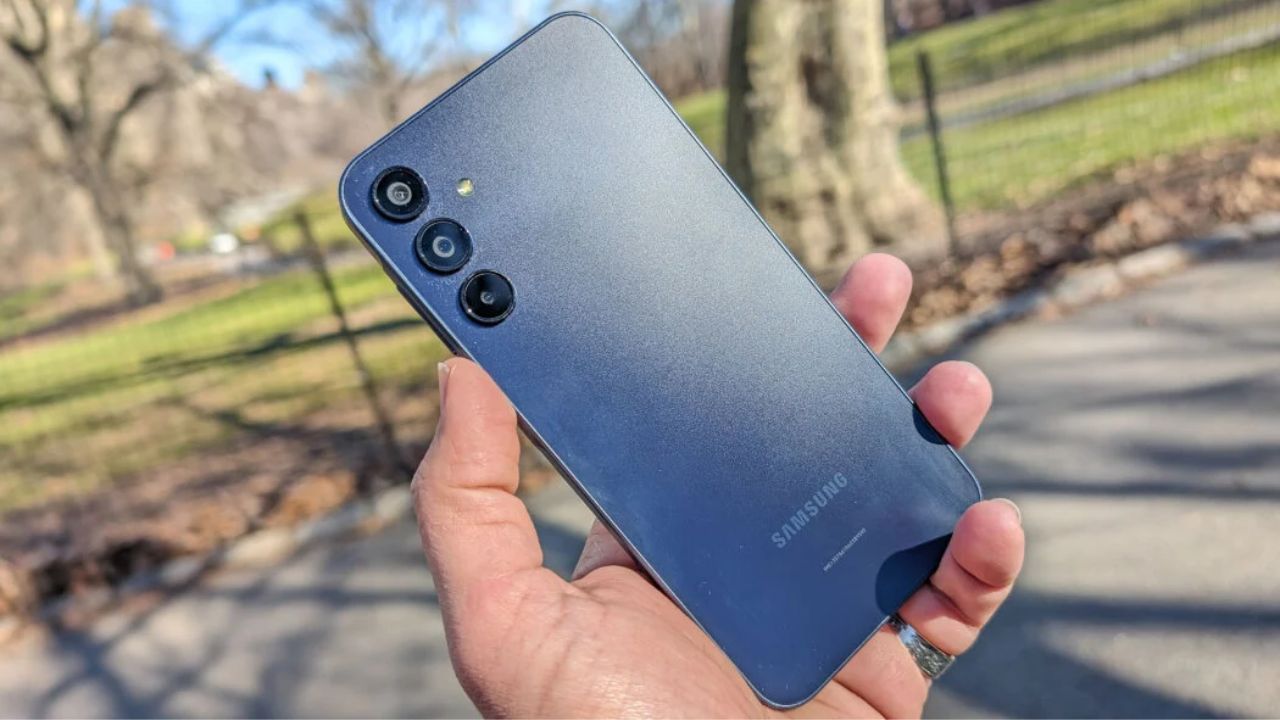 samsung galaxy A15 in blue color in hand infront of trees